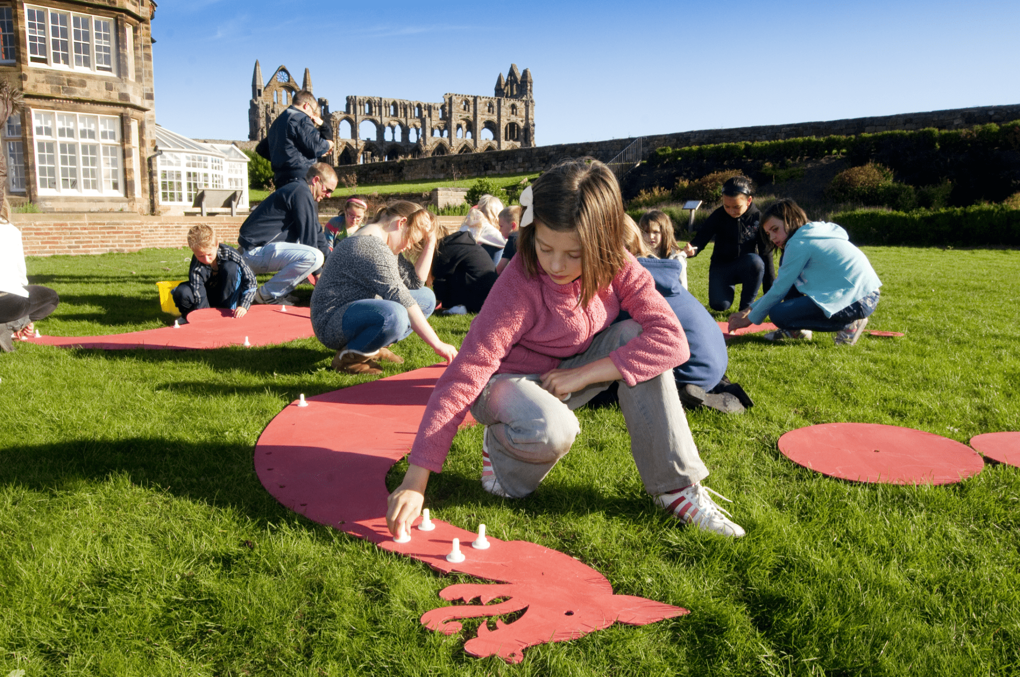 Children doing history activity in front of an Abbey