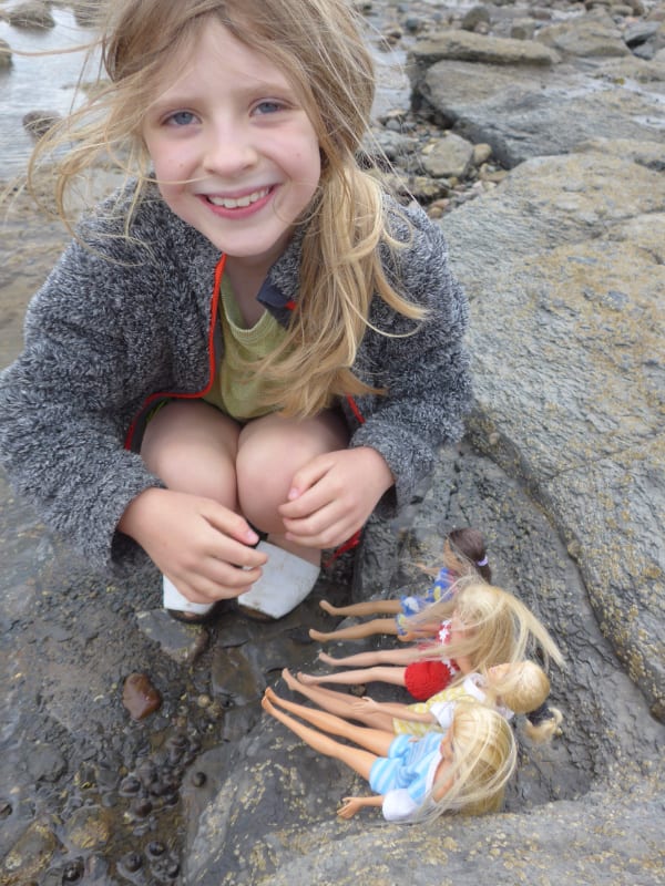 Child with dolls on Whitby beach