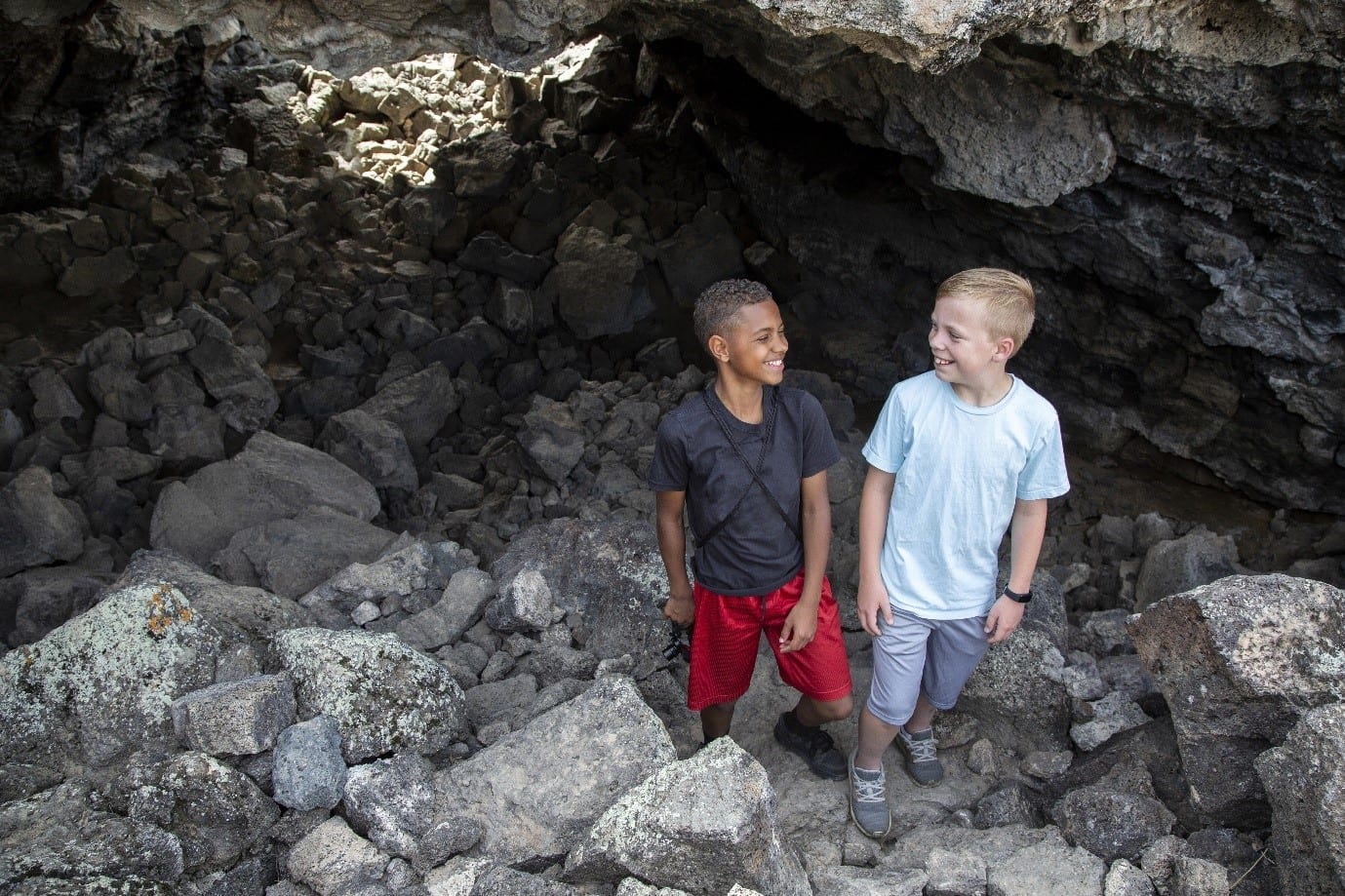 Two boys exploring a cave