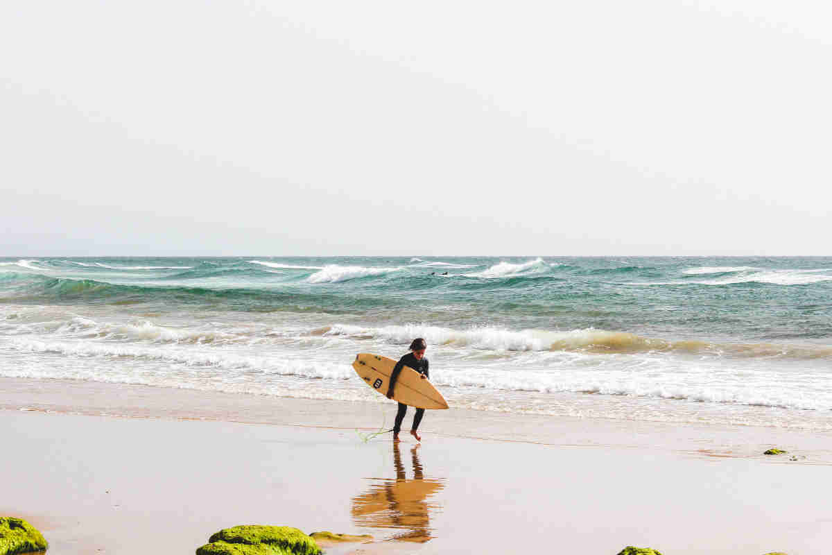 Boy surfing on the beach in Cornwall