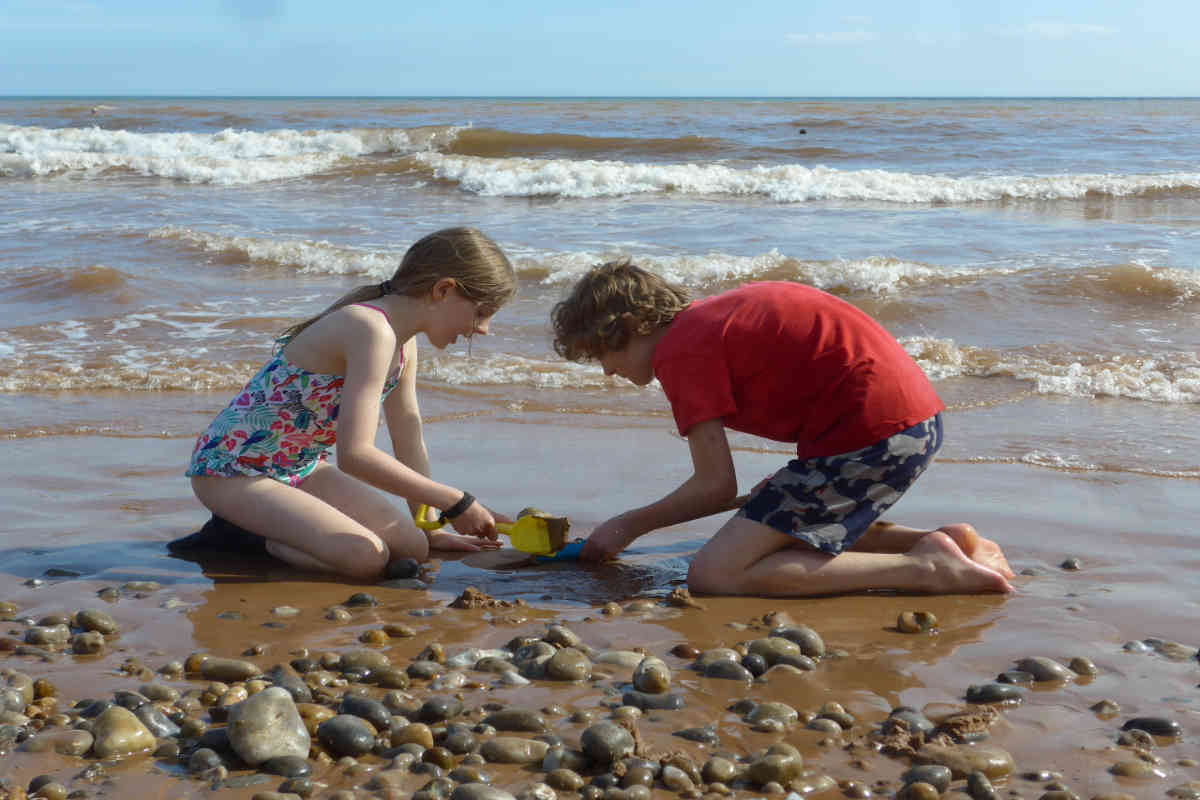 Boy and girl building a sandcastle on the beach