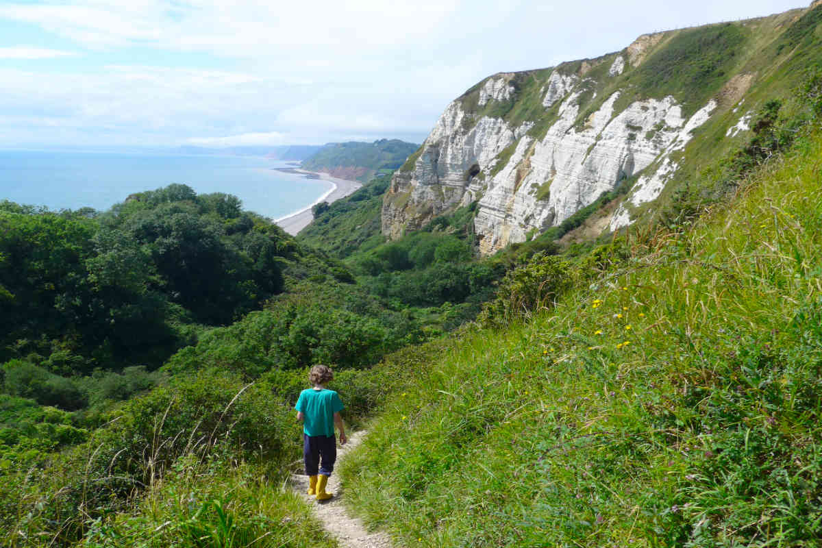 Boy walking down a coastal path in Devon