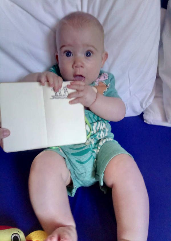 A baby holding the YHA stamp book