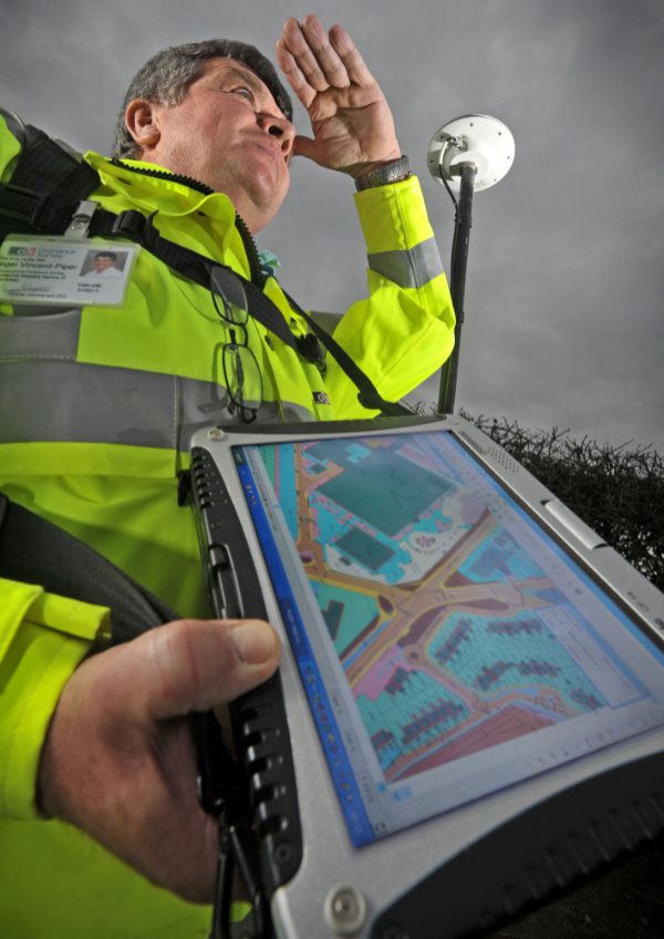 Man wearing high vis jacket using mapping device