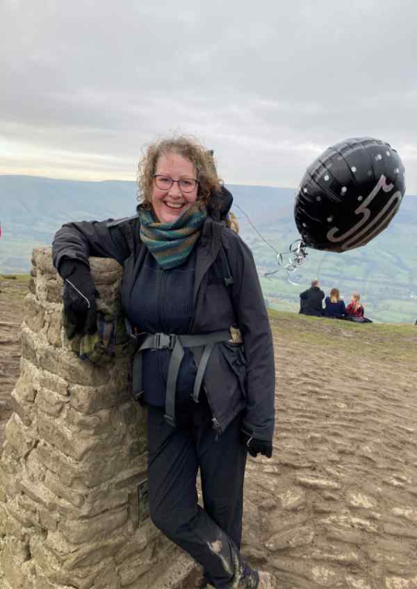 A woman stood at the Mam Tor view point in the Peak District