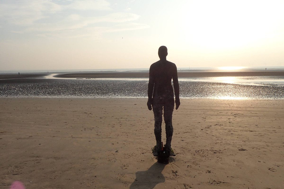 Statue of man standing on a beach