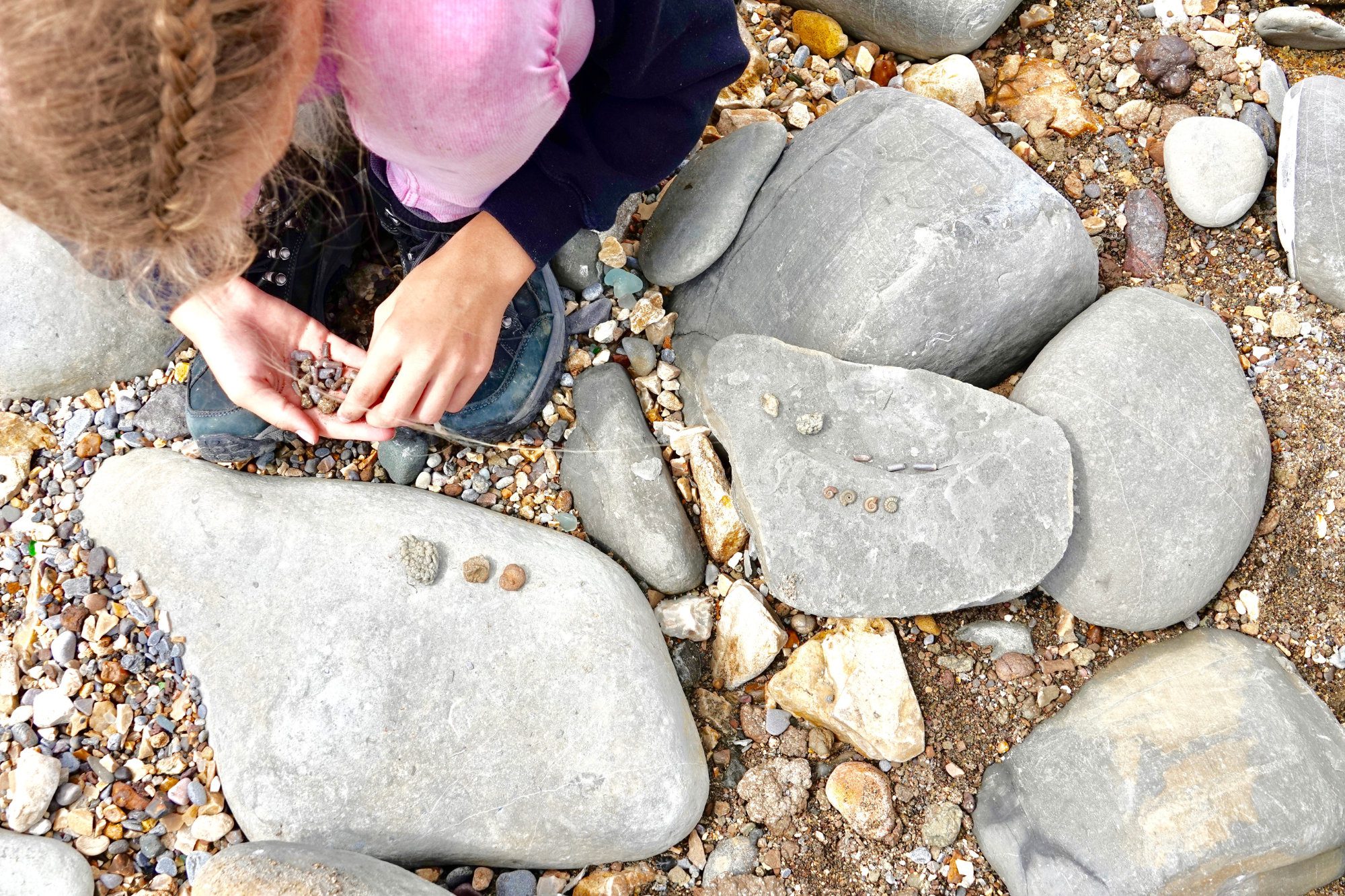Child looking at rocks on a beach