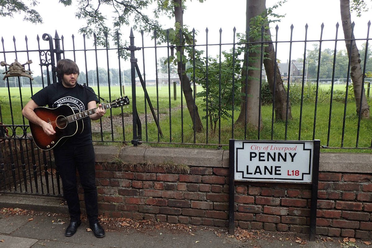 Musician playing guitar on Penny Lane