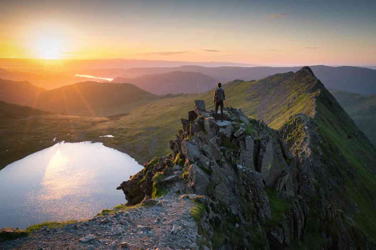 Hiker surveying the summit of Helvellyn at sunrise