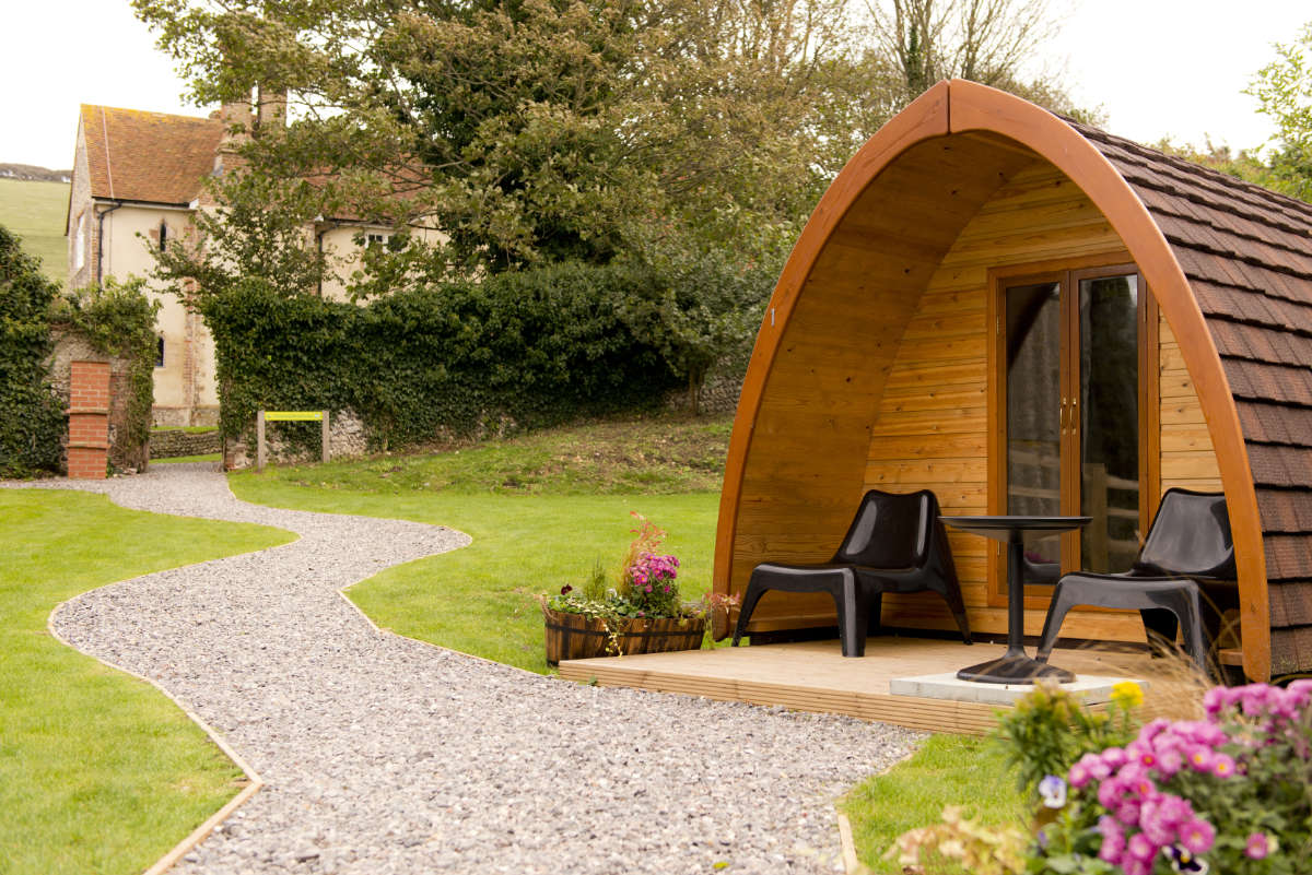 YHA Camping Pod in summer with flowers and a stone path close by