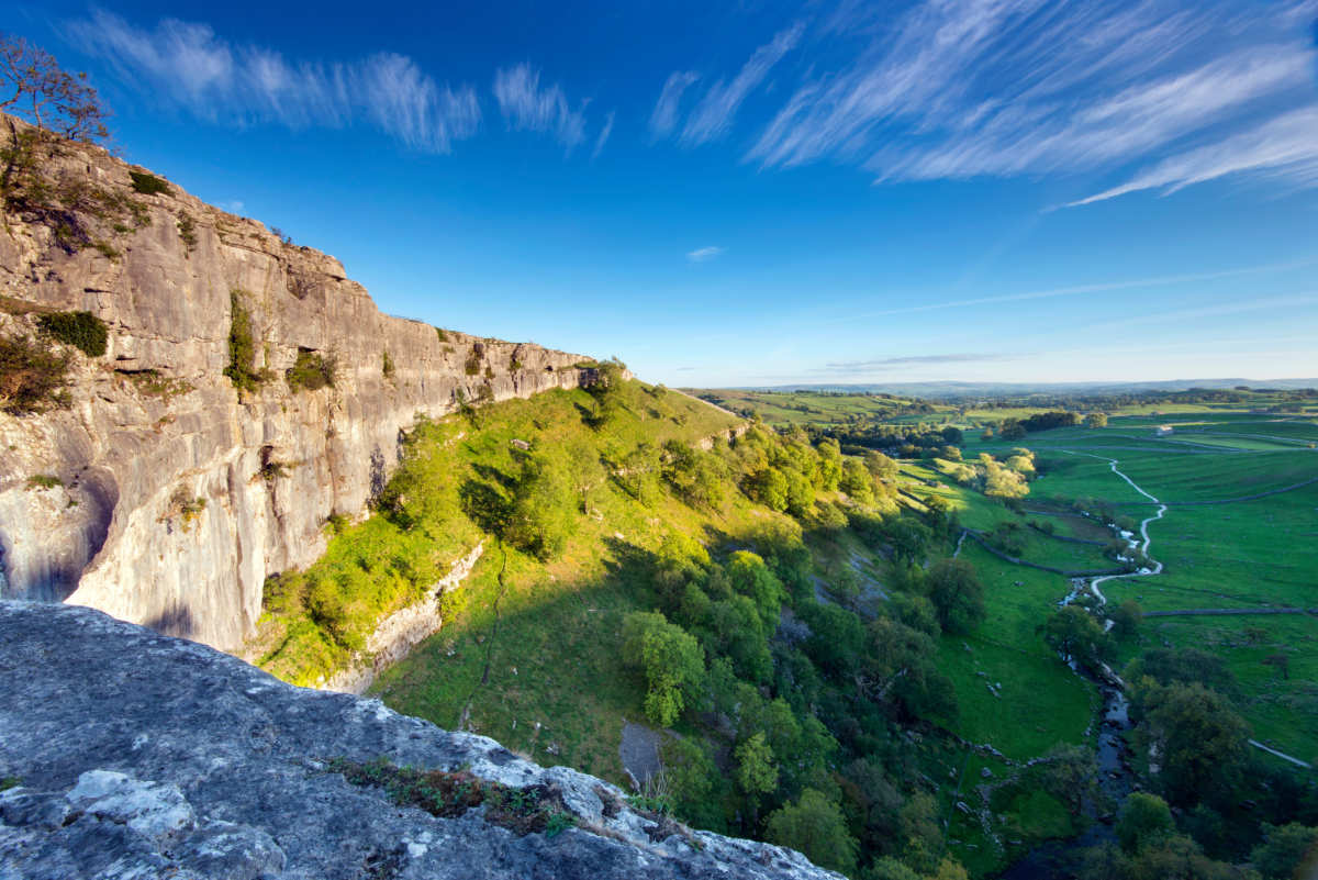 Malham cove and views over Malham Dale under a bright blue sky