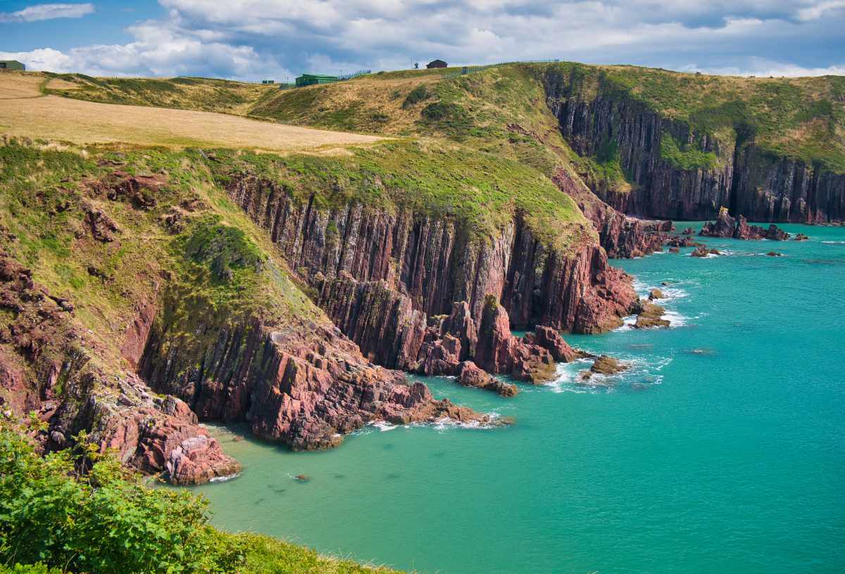 Coastal cliffs and bright turquoise waters near YHA Manorbier